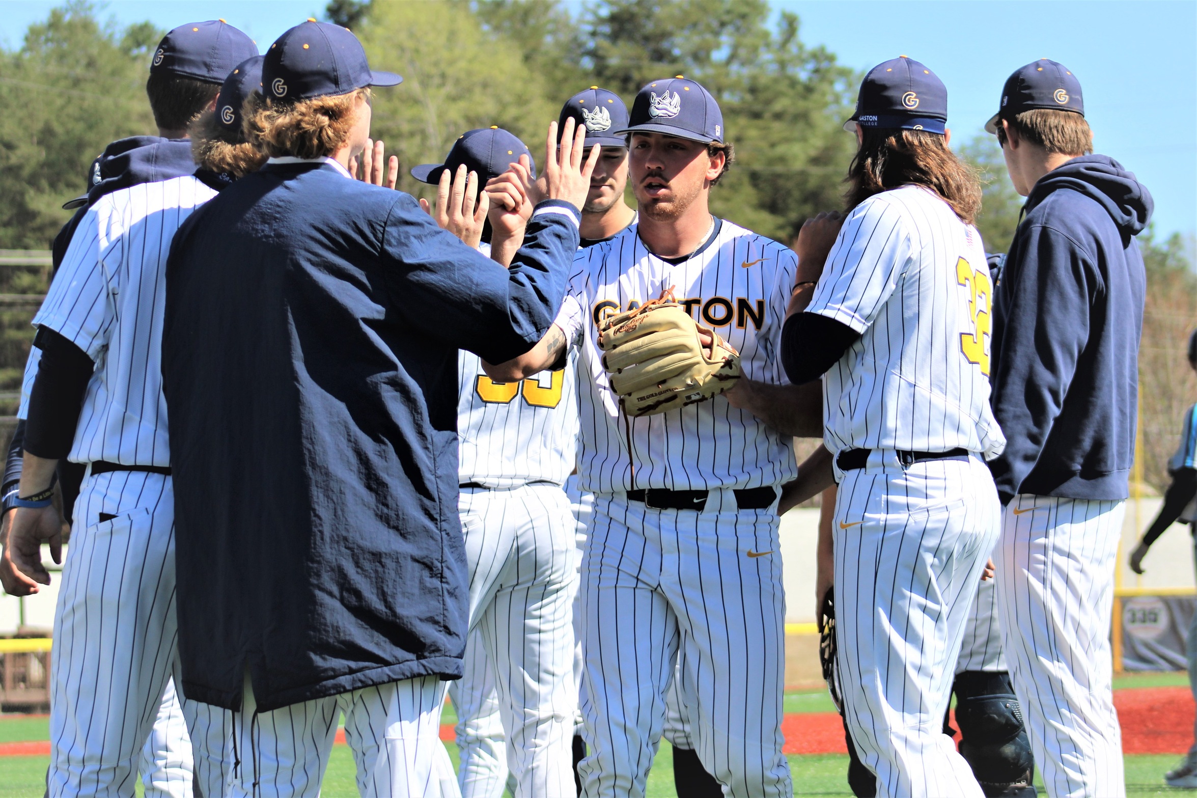 Gus Hughes (third from right) is greeted by teammates after an inning during his historic March 26 no-hitter at Gastonia's Sims Legion Park.