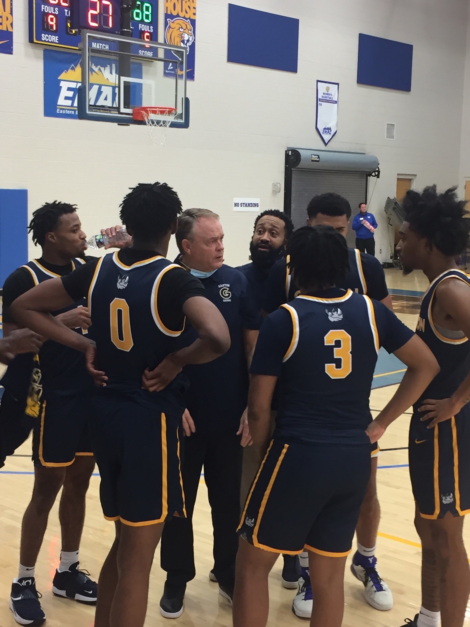 Gaston College head coach David Nutt (third from left) and associate head coach Jami Rosser (fourth from left) huddle with their team during the Nov. 5, 2021 season-opener at Johnson and Wales University in Charlotte.